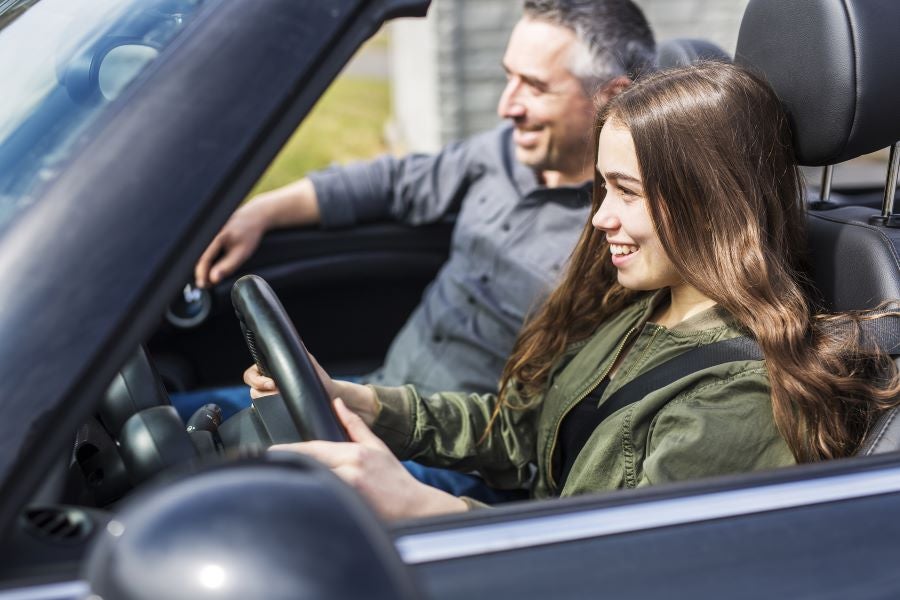 A Young Woman Driving A Vehicle Along With A Man